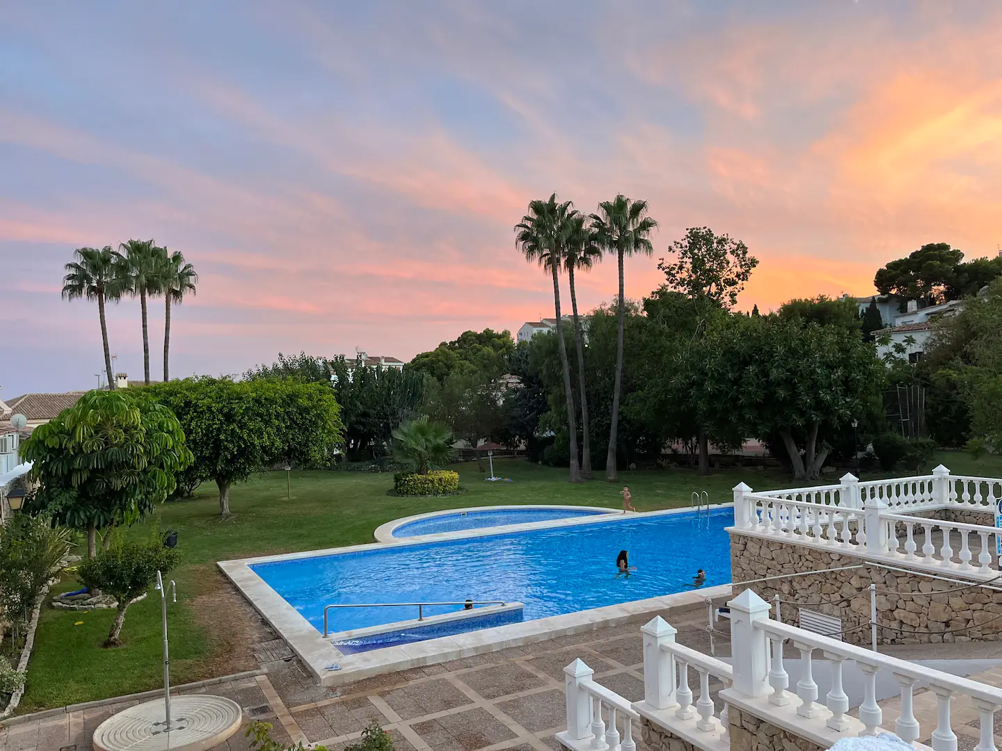 Piscina al atardecer con cielo rosado