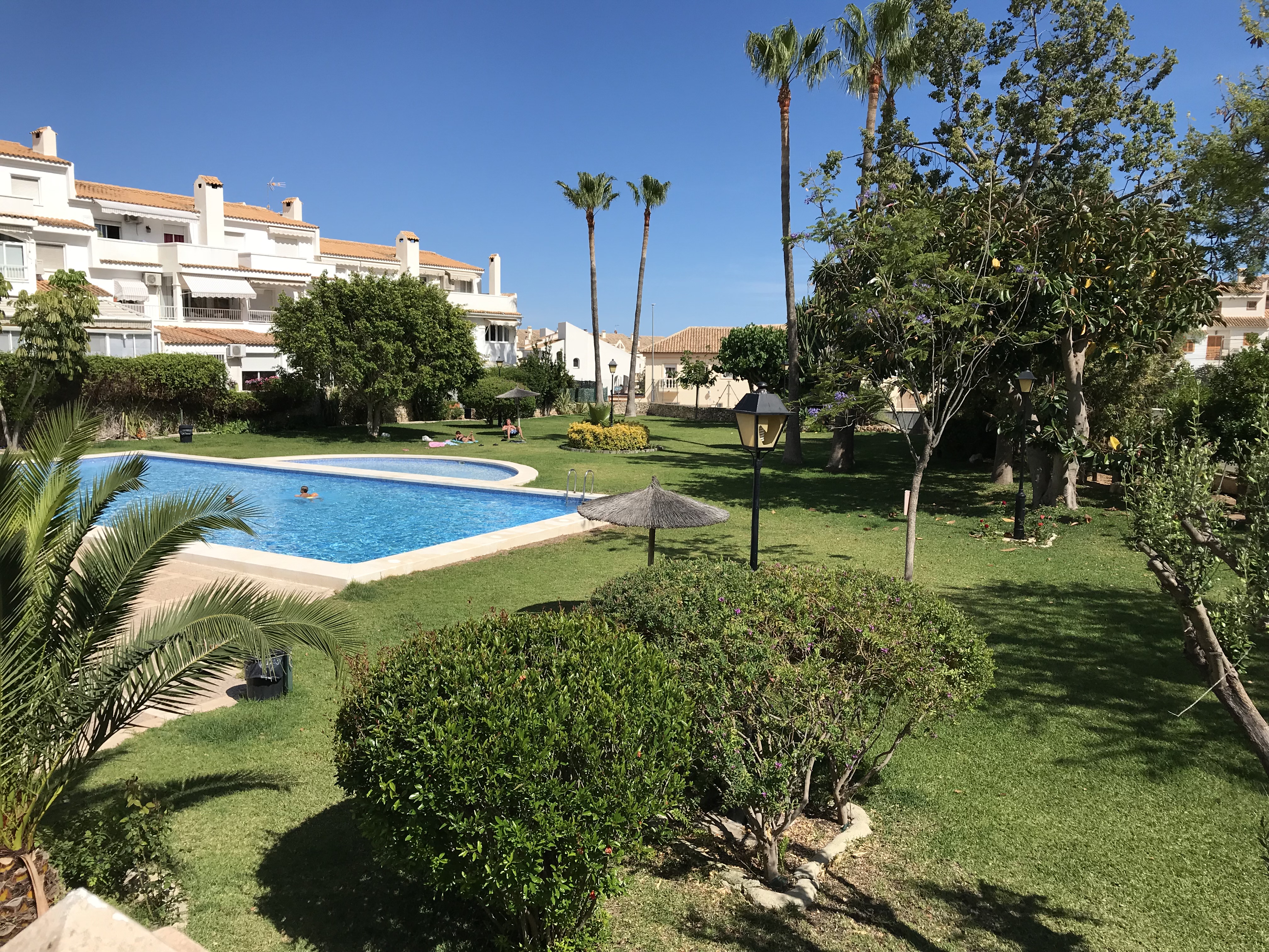 Jardines del complejo con sombrilla de paja